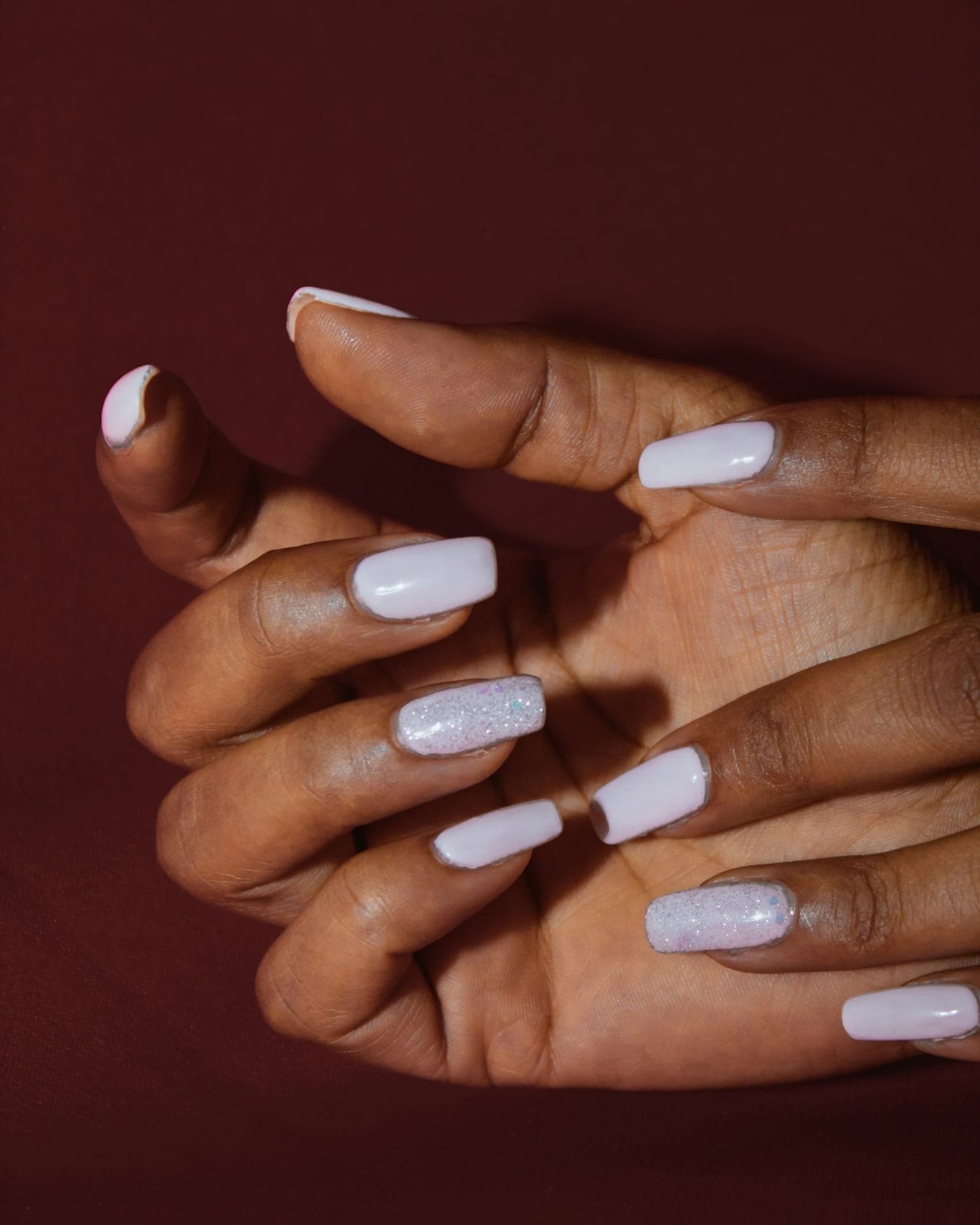 Unhas lilás peroladas com detalhe em glitter