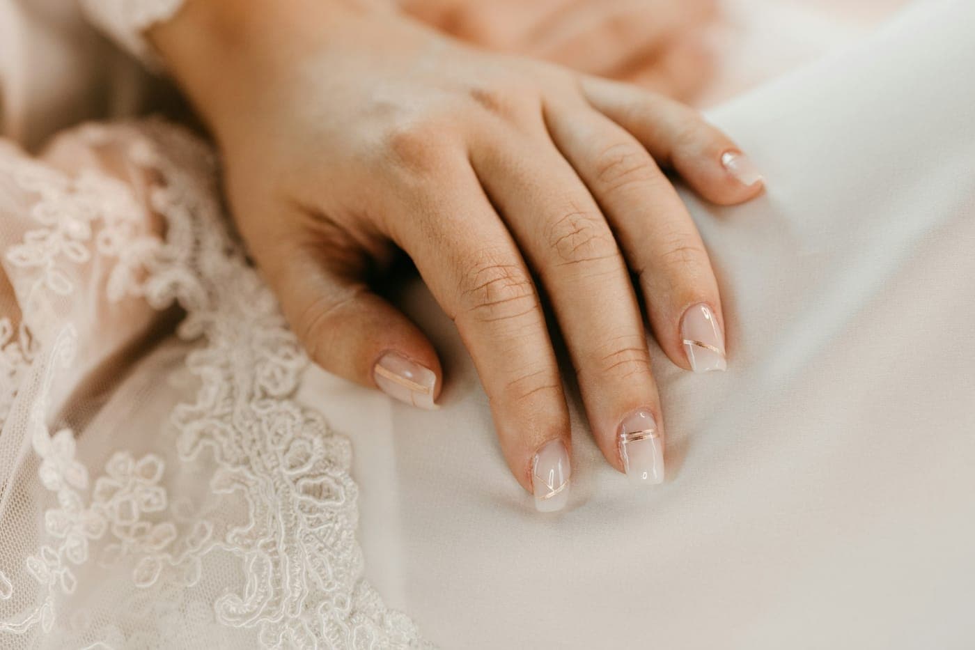 Unhas nude sobre renda branca
